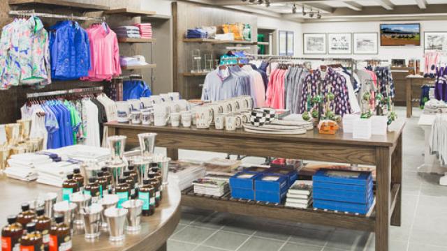 Interior of the Keeneland Shop, filled with bright blue, pink, and pastel shirts and silver drinkware.